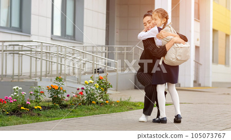 Black-haired mother meets girl child from primary school 105073767