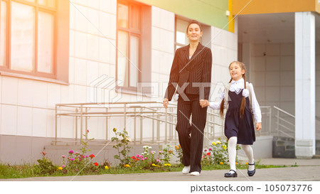 Mother and daughter go home from modern primary school 105073776