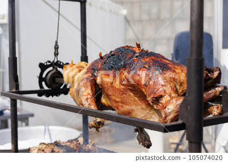 Barbeque. a whole carcass of sheep to roast on a spit. Food at the fair. 105074020