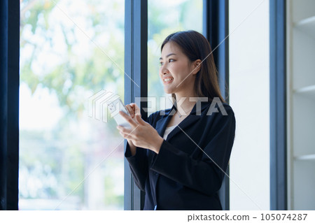 Asian businesswoman in office happy and cheerful during using smartphone and working. Female employees express the excitement of success and bonuses Asian businesswoman in office happy and cheerful during using smartphone and working. Female employees express the excitement of success and bonuses 105074287