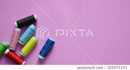 spools of thread on a pink background, photos for a sewing workshop, tailoring, a banner for an atelier, sewing threads, a place for text spools of thread on a pink background, photos for a sewing workshop, tailoring, a banner for an atelier, sewing threads, a place for text 105075333