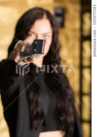 Beautiful young brutal woman male master hairdresser, barber holding razor for shaving Beautiful young brutal woman male master hairdresser, barber holding razor for shaving 105075381
