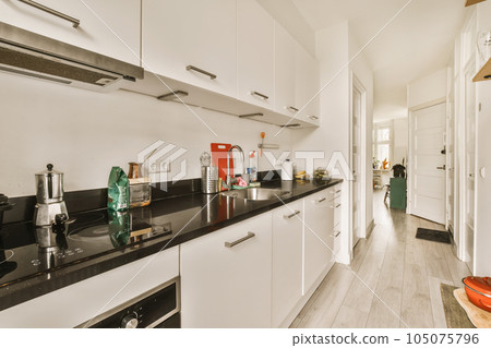 a kitchen area with white cabinets and black counter tops on the counters in this room is very clean, but it's not a kitchen area with white cabinets and black counter tops on the counters in this room is very clean, but it's not 105075796