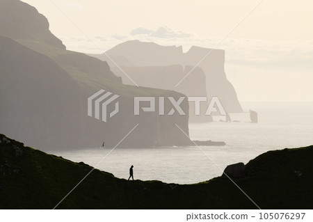 Man silhouette on background of famous Risin og Kellingin rocks Man silhouette on background of famous Risin og Kellingin rocks 105076297