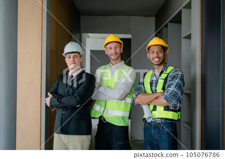 multi ethnic engineer brainstorming and measuring for cost estimating on blueprint and floor plan drawings about design architectural and engineering for houses and buildings. 105076786