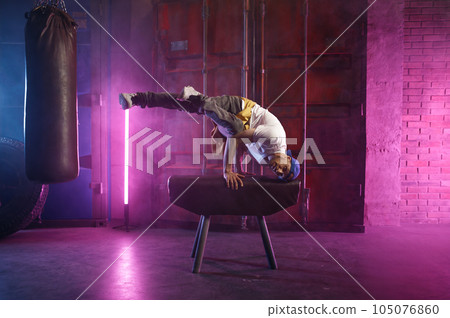 Male hip hop dancer on head stand doing acrobatic stunt Male hip hop dancer on head stand doing acrobatic stunt 105076860