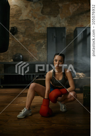 Portrait of young attractive woman boxer or kickboxer in gym 105076932