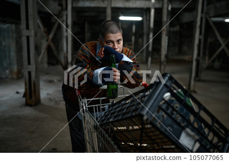 Portrait of unhappy young woman immigrant or beggar drinking beer Portrait of unhappy young woman immigrant or beggar drinking beer 105077065