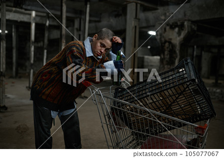 Portrait of unhappy young woman immigrant or beggar drinking beer Portrait of unhappy young woman immigrant or beggar drinking beer 105077067