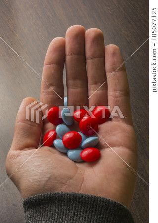 red and blue tablets in hand red and blue tablets in hand 105077125