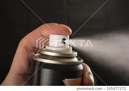 Close-up view of human hand and spray bottle isolated on black 105077172