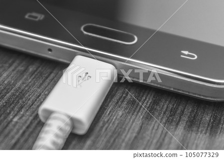 Phone photos charging on a gray background. Phone photos charging on a gray background. 105077329