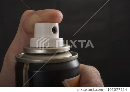 Close-up view of human hand and spray bottle isolated on black 105077514
