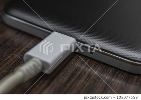 Mobile smart phones charging on wooden desk 105077559