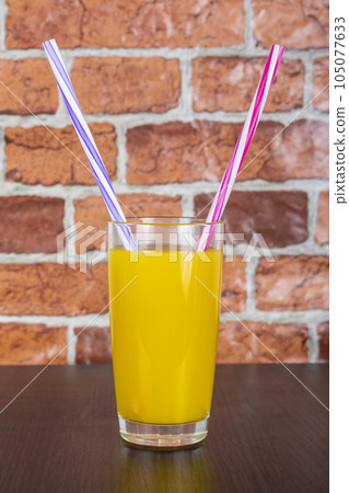Orange juice Two straws Vitamins Health concept wooden background and brick wall 105077633