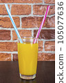 Orange juice Two straws Vitamins Health concept wooden background and brick wall 105077636