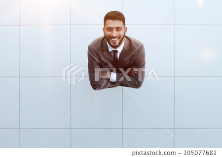 Handsome smiling business man in a suit standing with his arms crossed. 105077681