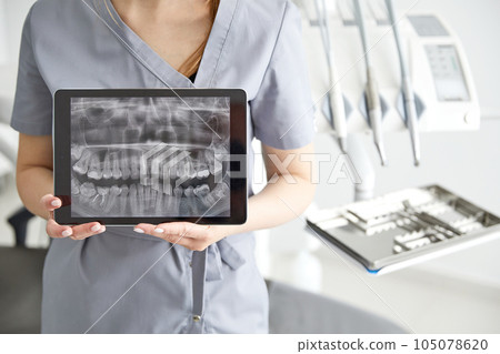 Young doctor in a dental clinic. Portrait of young female doctor dentist with digital tablet in dental office 105078620