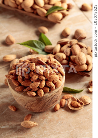 Almond nuts in a wooden bowl. 105078625