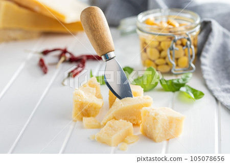 Tasty parmesan cheese on white table. Tasty parmesan cheese on white table. 105078656