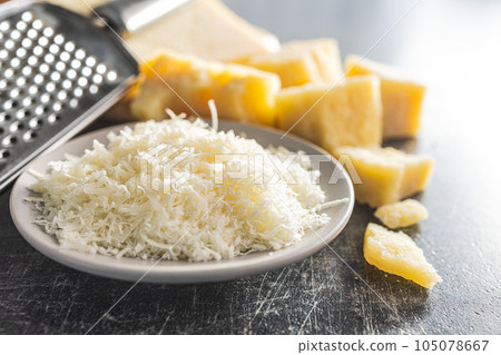 Grated parmesan cheese in bowl. Grated parmesan cheese in bowl. 105078667