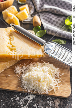 Grated parmesan cheese on cutting board. Grated parmesan cheese on cutting board. 105078669