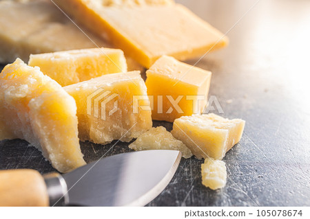 Tasty parmesan cheese on kitchen table. 105078674