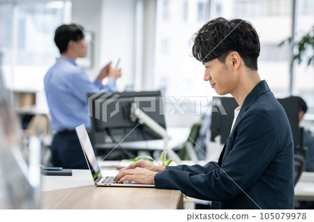 Profile of a businessman facing a laptop 105079978