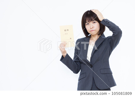 A business woman in her thirties who is worried about her salary bag in front of a white background A business woman in her thirties who is worried about her salary bag in front of a white background 105081809