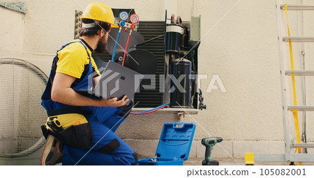 Skilled expert hired by business owner to detect cause of damage to air conditioner, writing down superheat and subcooling values measured by professional manifold indicators Skilled expert hired by business owner to detect cause of damage to air conditioner, writing down superheat and subcooling values measured by professional manifold indicators 105082001