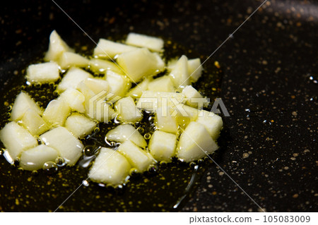 A cooking scene where garlic (coarsely chopped) is fried with olive oil. A cooking scene where garlic (coarsely chopped) is fried with olive oil. 105083009