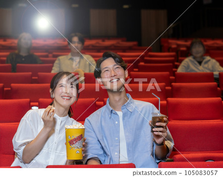 Couple watching a movie with a smile Couple watching a movie with a smile 105083057
