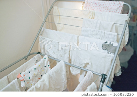 Baby's clothes, bodysuits and pants are dried after the laundry. Organization and cleaning in the 105083220