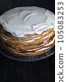 a whole round honey cake on a stand against a dark background 105083253