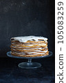 a whole round honey cake on a stand against a dark background 105083259