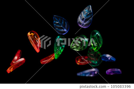 Fashion colorful plastic leaf with beautiful work detail is value. Luxury leaf bead red blue green is fashion trend and fly in air. Black background isolated selective focus blur 105083396