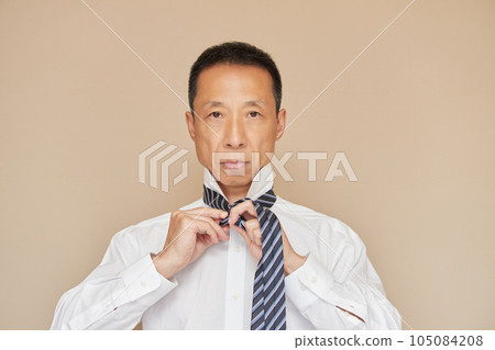 A middle-aged man tightening a tie for a job interview A middle-aged man tightening a tie for a job interview 105084208