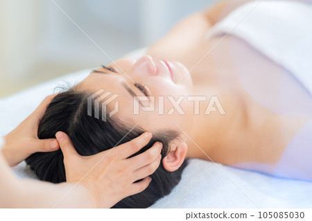 A young woman who is already having an esthetic treatment at an esthetic salon 105085030