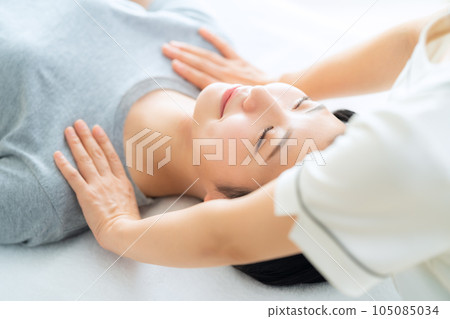 A young woman who receives a manipulative treatment at an osteopathic clinic 105085034