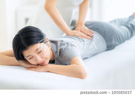 一名年輕女子在整骨診所接受手法治療 一名年輕女子在整骨診所接受手法治療 105085037