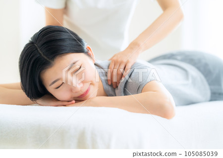 A young woman who receives a manipulative treatment at an osteopathic clinic 105085039