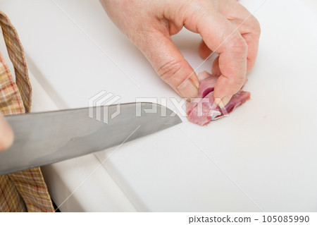 [Housewife preparing yakitori gizzards with a knife] 105085990