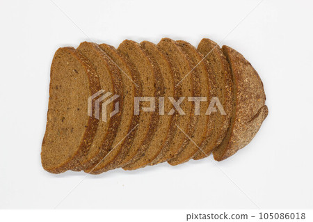 Sliced black bread. Dark rye bread with cumin cut into even pieces on a white background. Wheat black bread on the table. Isolated. Bran from grain. Healthy food. Vegetarian food. Ecological friendly Sliced black bread. Dark rye bread with cumin cut into even pieces on a white background. Wheat black bread on the table. Isolated. Bran from grain. Healthy food. Vegetarian food. Ecological friendly 105086018