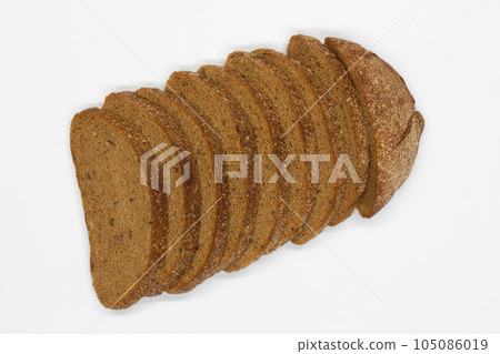 Sliced black bread. Dark rye bread with cumin cut into even pieces on a white background. Wheat black bread on the table. Isolated. Bran from grain. Healthy food. Vegetarian food. Ecological friendly 105086019