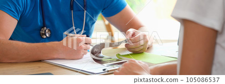 Doctor diagnoses patient by looking at ultrasound results. 105086537