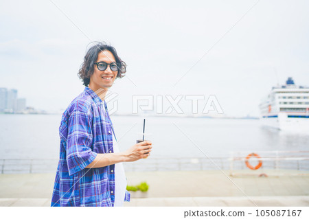 一個男人拿著外賣咖啡沿著海灘散步 一個男人拿著外賣咖啡沿著海灘散步 105087167