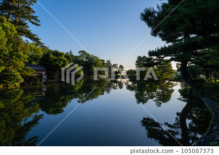 黎明時分的兼六園霞池，清晨的陽光照射進來，形成美麗的水鏡景觀｜石川縣金澤市 105087373