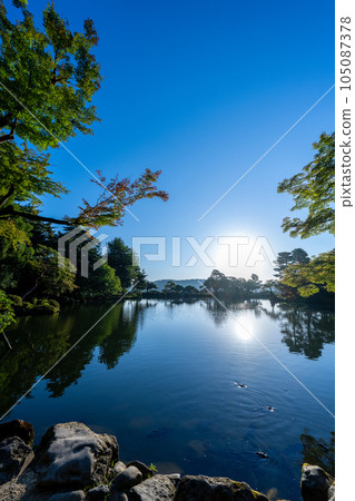 黎明時分的兼六園霞池，清晨的陽光照射進來，形成美麗的水鏡景觀｜石川縣金澤市 105087378