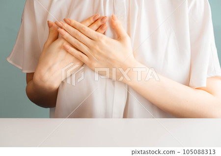 把她的手放的婦女在她的胸口上 105088313