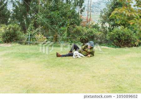 The owner's man, camper who plays with his dog at the campsite 105089602